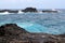 Pacific Ocean contrasted against a black volcanic shoreline in Maui, Hawaii