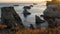 The Pacific Ocean and rocky cliffs at sunset. Scenic seascape, and sun setting down the horizon