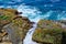 Pacific Ocean Waves Washing Into Rock Fissure on Shoreline