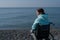 Pacified caucasian woman in a wheelchair on the seashore.