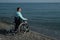 Pacified caucasian woman in a wheelchair on the seashore.