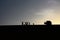 A pack of adventurers salute from the top of a grand sand dune while enjoying a beautiful summer sunset in Dakhla Oasis, Egypt