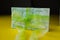 Pack of hundred euro banknotes with green bow-knot on yellow desk, gift or dividends concept, european union money