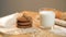 A pack of oat biscuits next to a glass of tin on the table view from the side .Village style on a light background