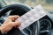 Pack of pills in the hands of the driver on a blurred background of the steering wheel in the car