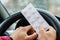 Pack of pills in the hands of the driver on a blurred background of the steering wheel in the car