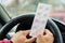 Pack of pills in the hands of the driver on a blurred background of the steering wheel in the car