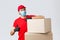 Packages and parcels delivery, covid-19 quarantine and transfer orders. Confident courier in red uniform, gloves and