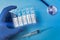 Packaging of ampoules with the vaccine COVID-19 in hand. Close-up. Pandemic Control Concept. Syringe, blue background