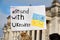 Packard with text Stand with Ukraine, Ukrainian yellow blue flag and peace dove in hand in Berlin.