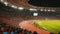 Packed with fervent fans, the stadium pulses with energy as athletes compete in a gripping sports event