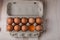 Packing chicken eggs with one broken on a wooden background