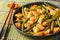 Pad prik king is a Thai stir-fried dish featuring chicken meat, stir-fried with red curry paste, long beans, and sometimes kaffir