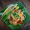 Pad Thai fried noodles popular street food delicious with green Banana leaf is the famous favorite Thai cuisine style on old