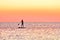 Paddle boarding at sunset. Silhouette of sup surf swimmer