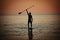 Paddle standing, silhouette of man on the beach at sunset