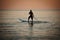 Paddle standing, silhouette of man on the beach at sunset