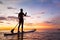 Paddleboard on the beach at sunset, SUP, leisure activity