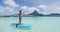 Paddleboard woman relaxing at Bora Bora luxury hotel resort vacation in Tahiti