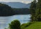 A paddler on a paddleboard enjoys a summer afternoon on a pristine lake