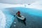 Paddling to rocky shore of blue lake on white ice of the Matanuska Glacier. All these rocks are just moraine riding on top of the