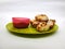 Paddu or Kuzhi paniyaram and Coconut Chutney in a Green Plate isolated on White Background. Indian dish made by steaming batter