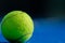 Padel tennis ball on a blue court with the net out of focus in the background