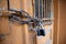 Padlock and chain on a wooden door with bars