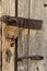 A padlock with keys hangs on an old door. Rustic style, shabby wood, rust on metal