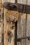 A padlock with keys hangs on an old door. Rustic style, shabby wood, rust on metal