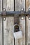 Padlock on old wooden gate