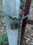 Padlock on the street gate. The door is chained and padlocked. Hinged block on the doors in the yard