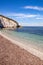 Padulella beach with iconic capo bianco cliff, its clear water and seagrass on the white pebble beach at Portoferraio, Island of E