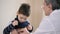 Paediatrician man examining heartbeat of kid boy with stethoscope
