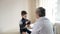 Paediatrician man examining heartbeat of kid boy with stethoscope