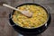 Paella with chicken, peas, sweetcorn and pepper cooking on an outdoor camping cooker