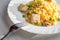 Paella with chicken and seafood on white plate. Spanish dish served on table