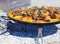 Paella cooking over hot coals