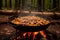 paella pan simmering on open campfire flames