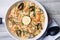 Paella with tiger shrimps, mussels, salmon and olives.