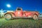 PAGE, AZ - JUNE 27, 2018: Old vintage rusty car in fornt of Page United Firefighters Department at night