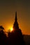 Pagoda silhouette on rock in golden sunlight shade