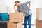 Pain in back. Young man suffering while lifting a cardboard box