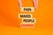 Pain makes people change symbol. Concept words Pain makes people change on wooden blocks on a beautiful orange table orange