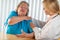 Pained Senior Woman Consults with Female Doctor About Sore Shoulder