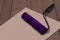 Paint brush roller on white paper and wooden background. Purple used paint tool as a concept of refurbishing, re branding and