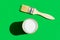 Paint brush with wooden handle can of varnish on trendy green background. Interior design home refurbishing fashion concept