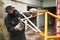 Paint removal: man using a wire brush over a bike frame after using a blowtorch