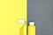 Paint roller and bottle with colorful pigment on yellow-gray background. house renovation