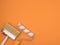 A paint roller and a large brush on an orange background